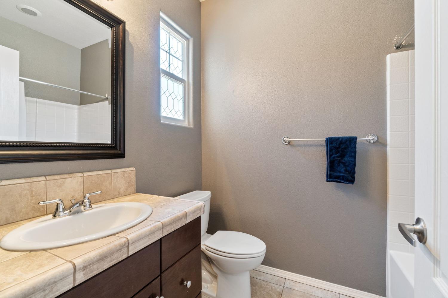 3915 Harlan Ranch Boulevard Clovis, CA 93619 - Photo 19 of 27 a bathroom with a toilet sink and mirror