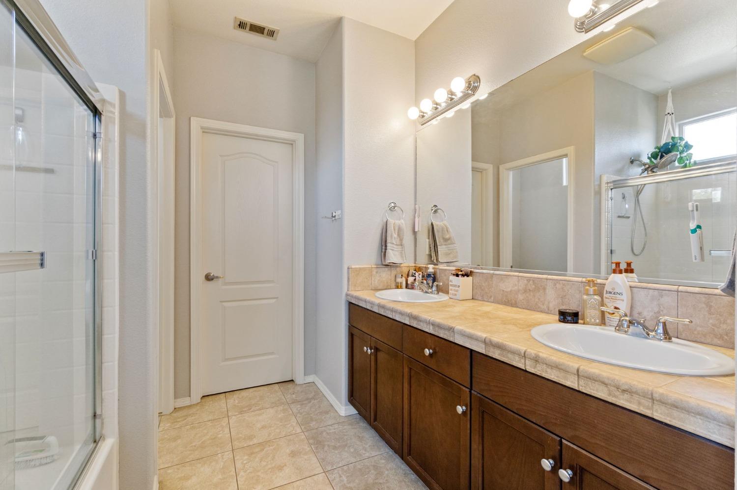 3915 Harlan Ranch Boulevard Clovis, CA 93619 - Photo 23 of 27 a bathroom with a granite countertop sink and a mirror