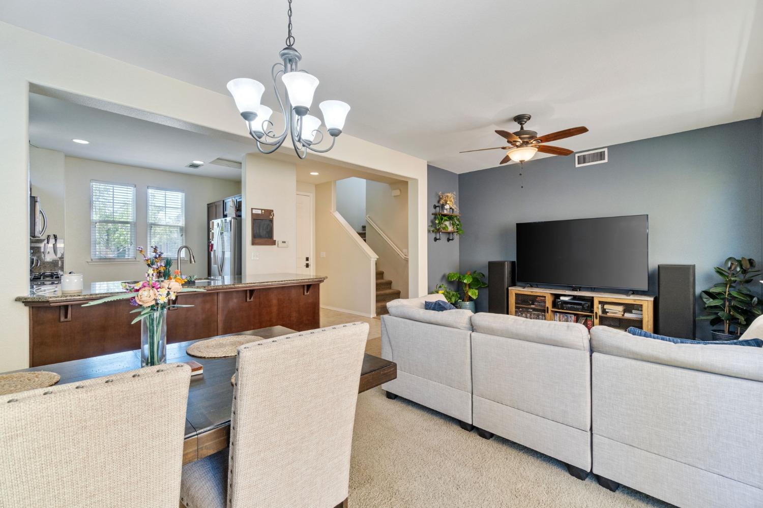 3915 Harlan Ranch Boulevard Clovis, CA 93619 - Photo 7 of 27 a living room with furniture a chandelier and a flat screen tv