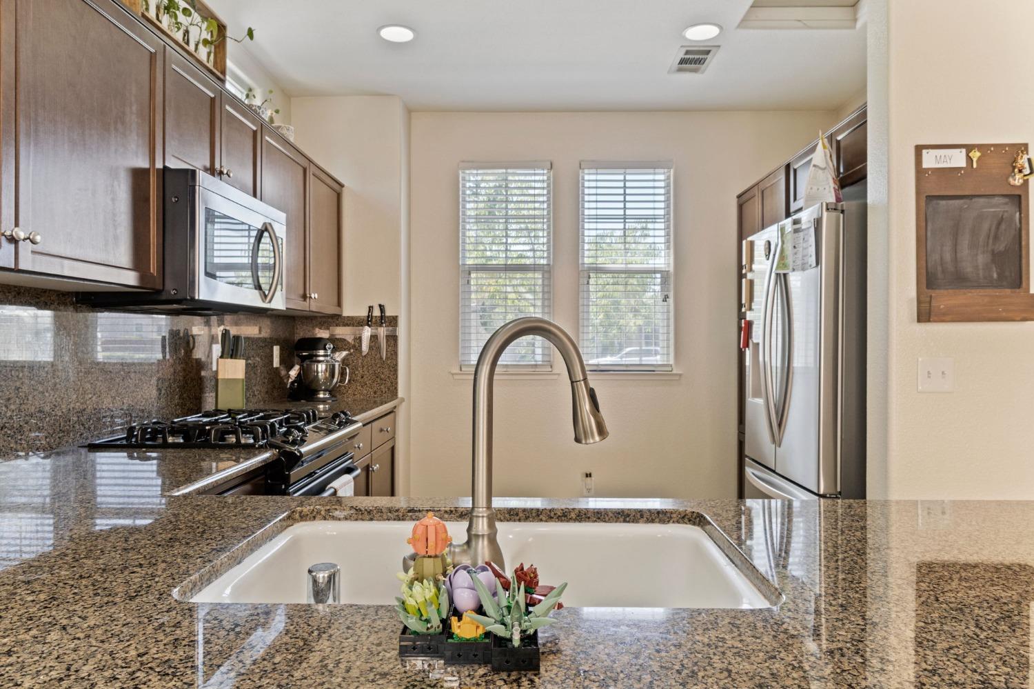 3915 Harlan Ranch Boulevard Clovis, CA 93619 - Photo 10 of 27 a kitchen with stainless steel appliances granite countertop a refrigerator and a sink