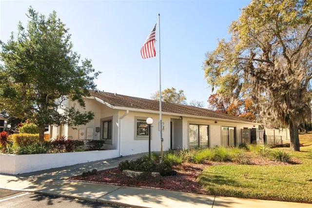 a front view of a house with a porch and tree