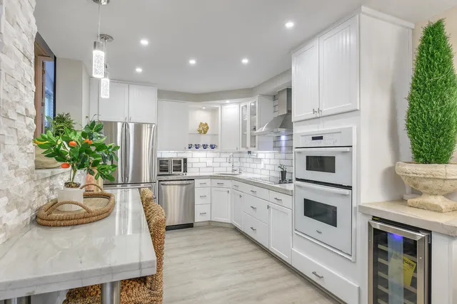 a kitchen with stainless steel appliances kitchen island granite countertop a stove a sink and a refrigerator