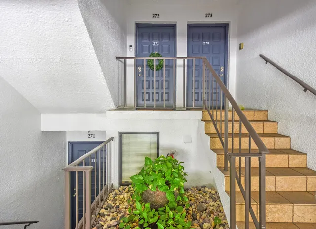 a view of staircase with railing and a flower pot
