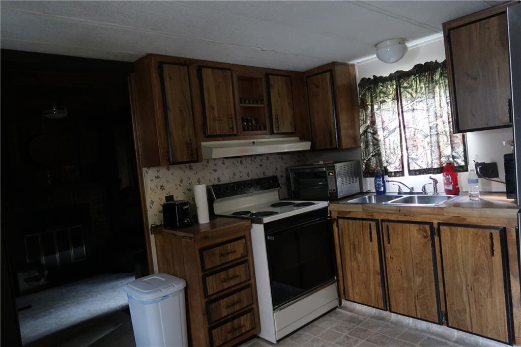 117 Esposito Road Mercer, PA 16137 - Photo 10 of 32 a kitchen with stainless steel appliances granite countertop a stove a sink and a microwave