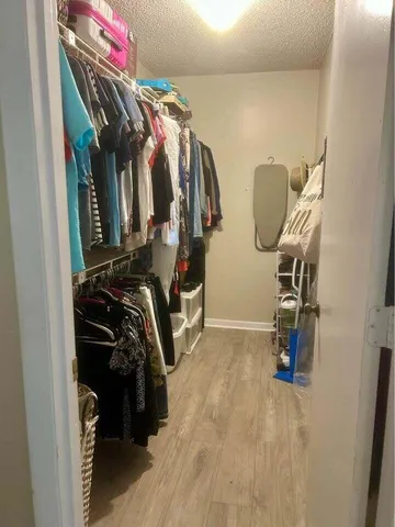 a view of walk in closet with clothes and shoes
