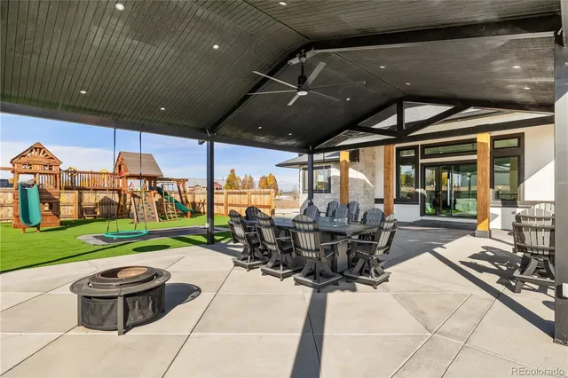 a view of a patio with table and chairs potted plants with wooden floor and fence