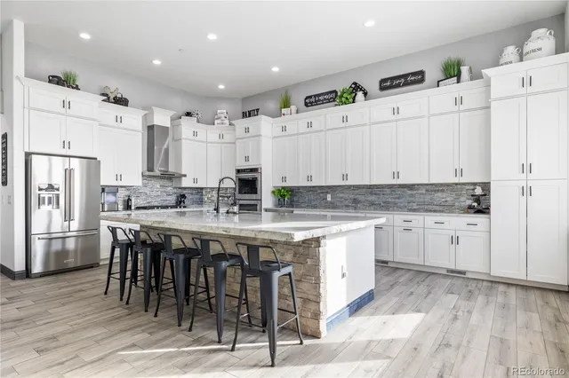 a kitchen with stainless steel appliances granite countertop a sink a stove and cabinets