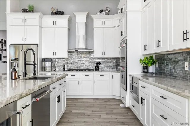 a large kitchen with stainless steel appliances kitchen island granite countertop a large counter top and a stove top oven