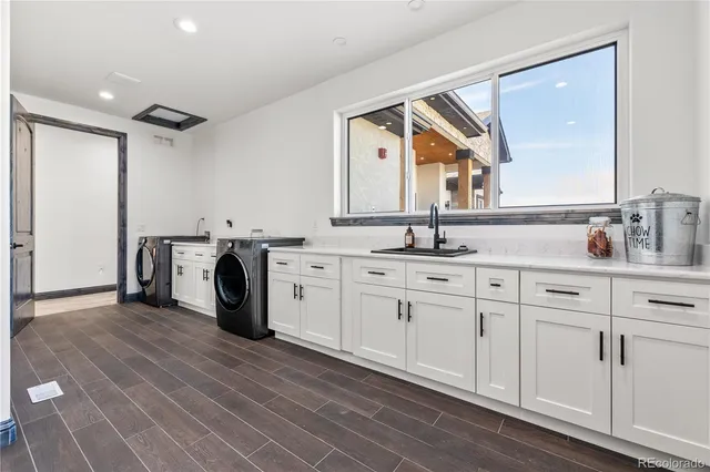a view of a kitchen with kitchen island a sink and wooden floor