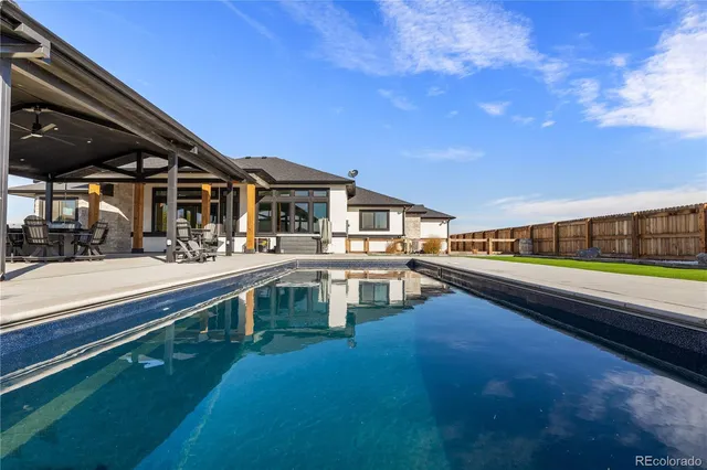 a view of a house with pool and chairs