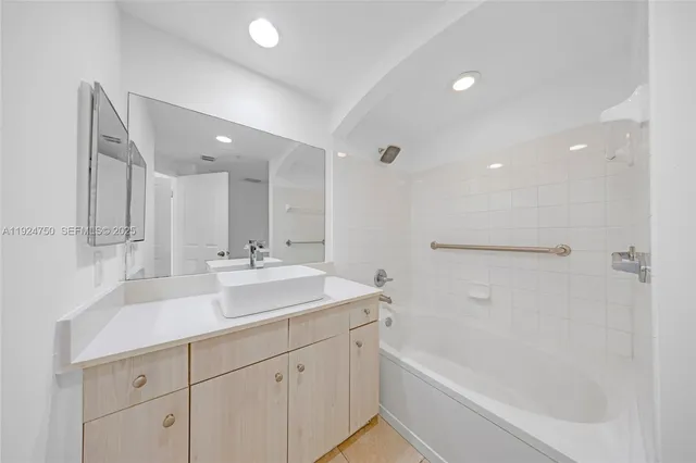 a bathroom with a sink double vanity granite tub shower and a mirror