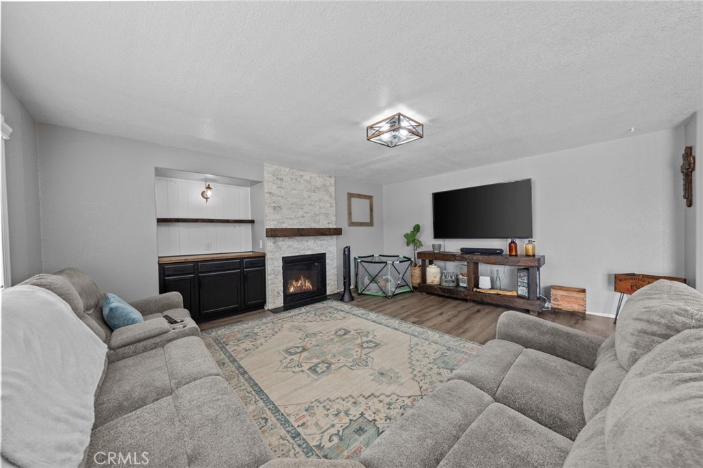 29266 Granite Ridge Court Menifee, CA 92587 - Photo 19 of 51 a living room with furniture a fireplace and a flat screen tv