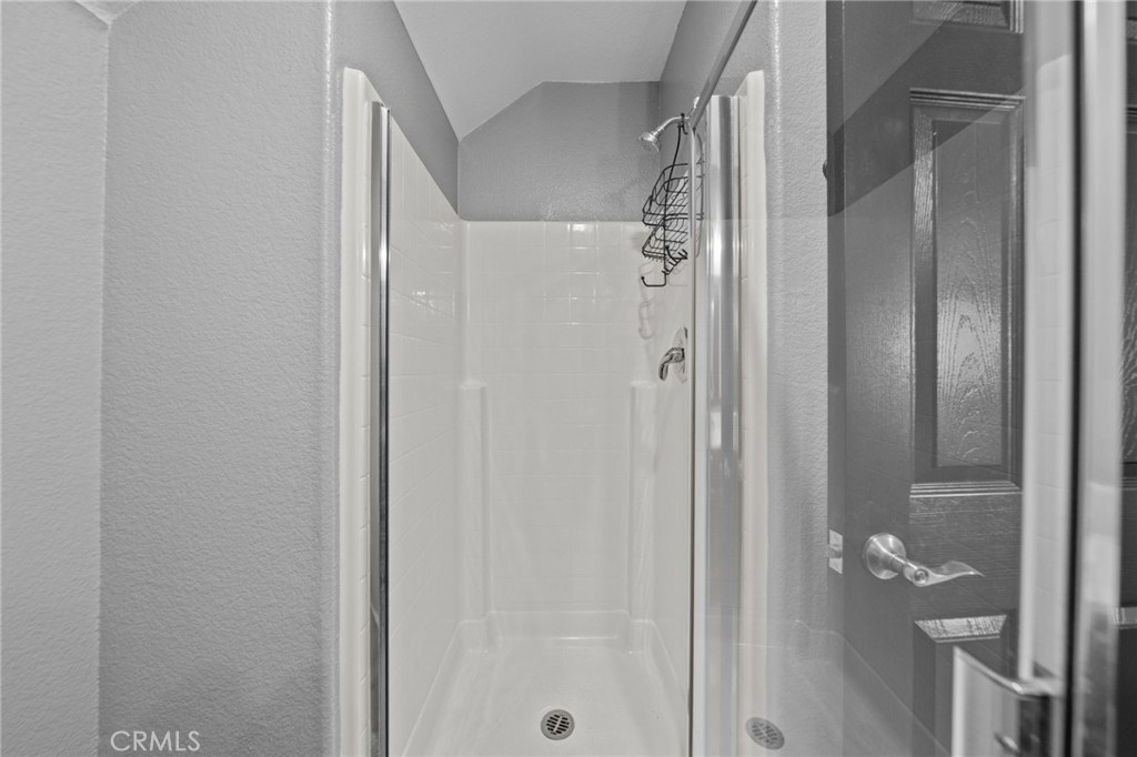 29266 Granite Ridge Court Menifee, CA 92587 - Photo 25 of 51 a bathroom with a glass shower door and a shower curtain