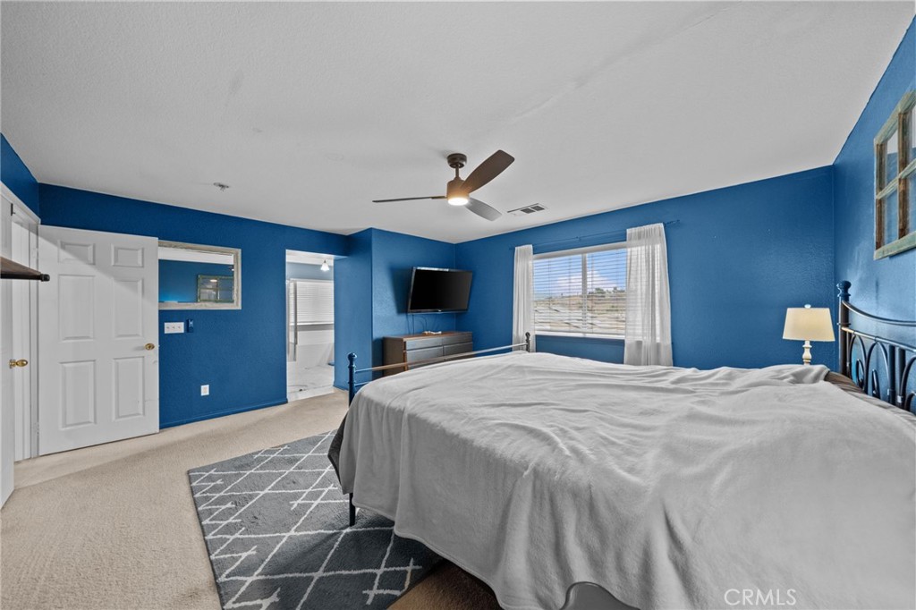 29266 Granite Ridge Court Menifee, CA 92587 - Photo 28 of 51 a bedroom with a large bed and a chandelier