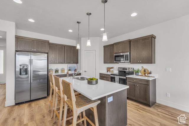 155 East 360th Street East, Unit 10B Fillmore, UT 84631 - Photo 11 of 43 Kitchen with a kitchen bar, light wood-type flooring, stainless steel appliances, decorative light fixtures, and an island with sink