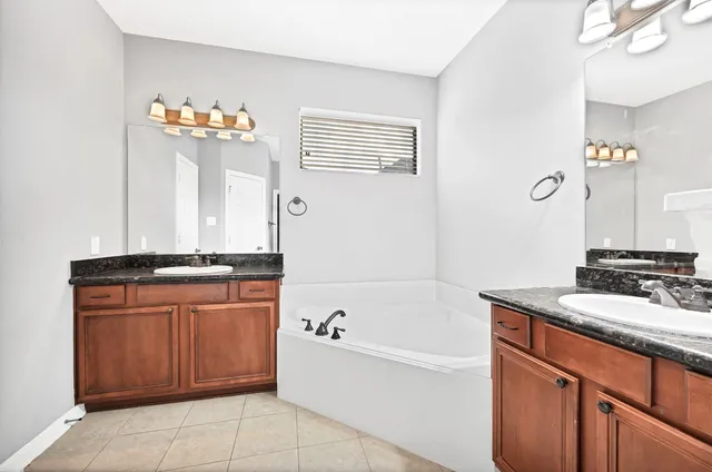 a bathroom with a sink a bathtub and a mirror