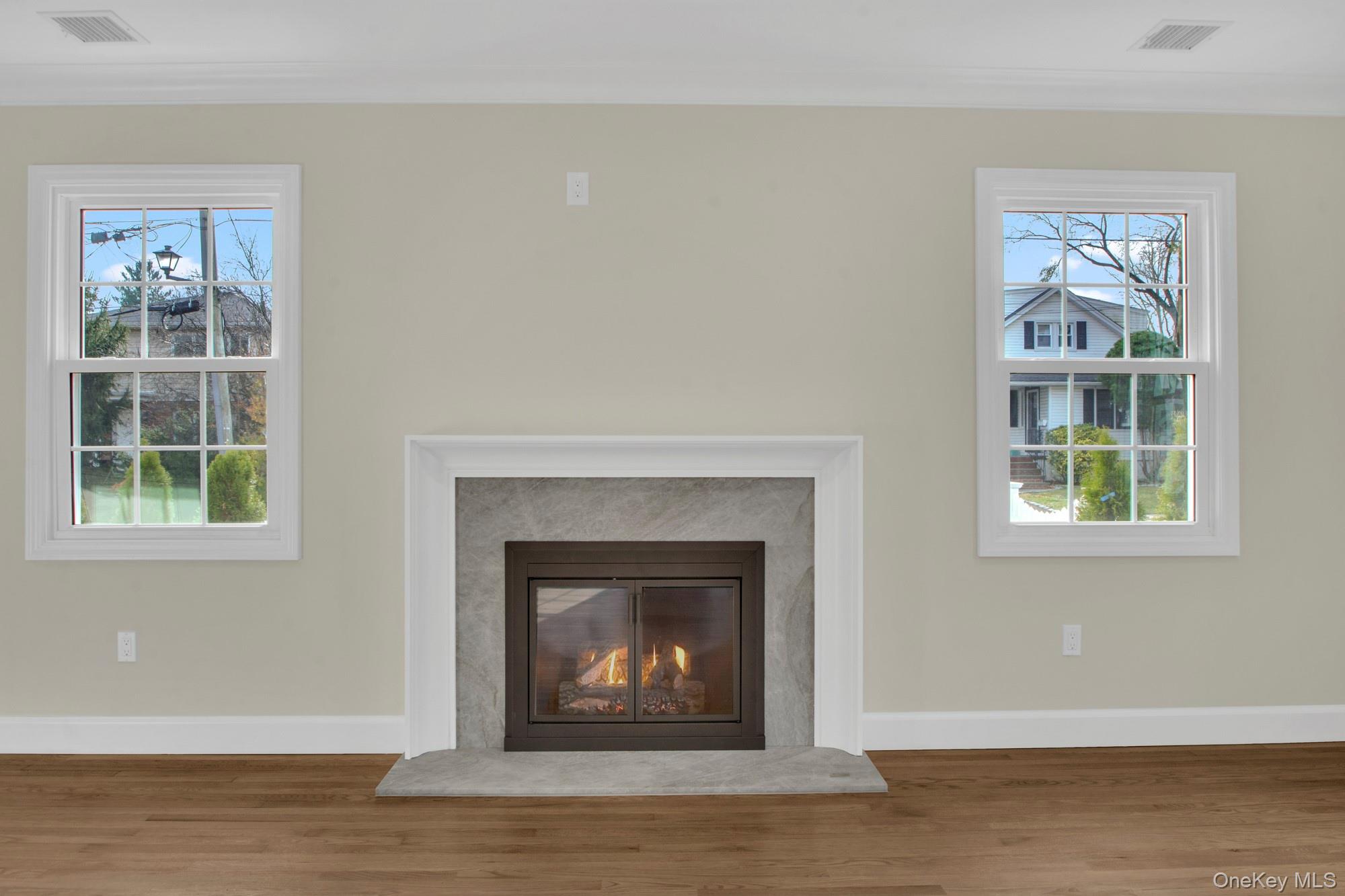 2 Bayview Court Manhasset, NY 11030 - Photo 6 of 21 Detailed view of a glass covered fireplace, wood finished floors, and ornamental molding