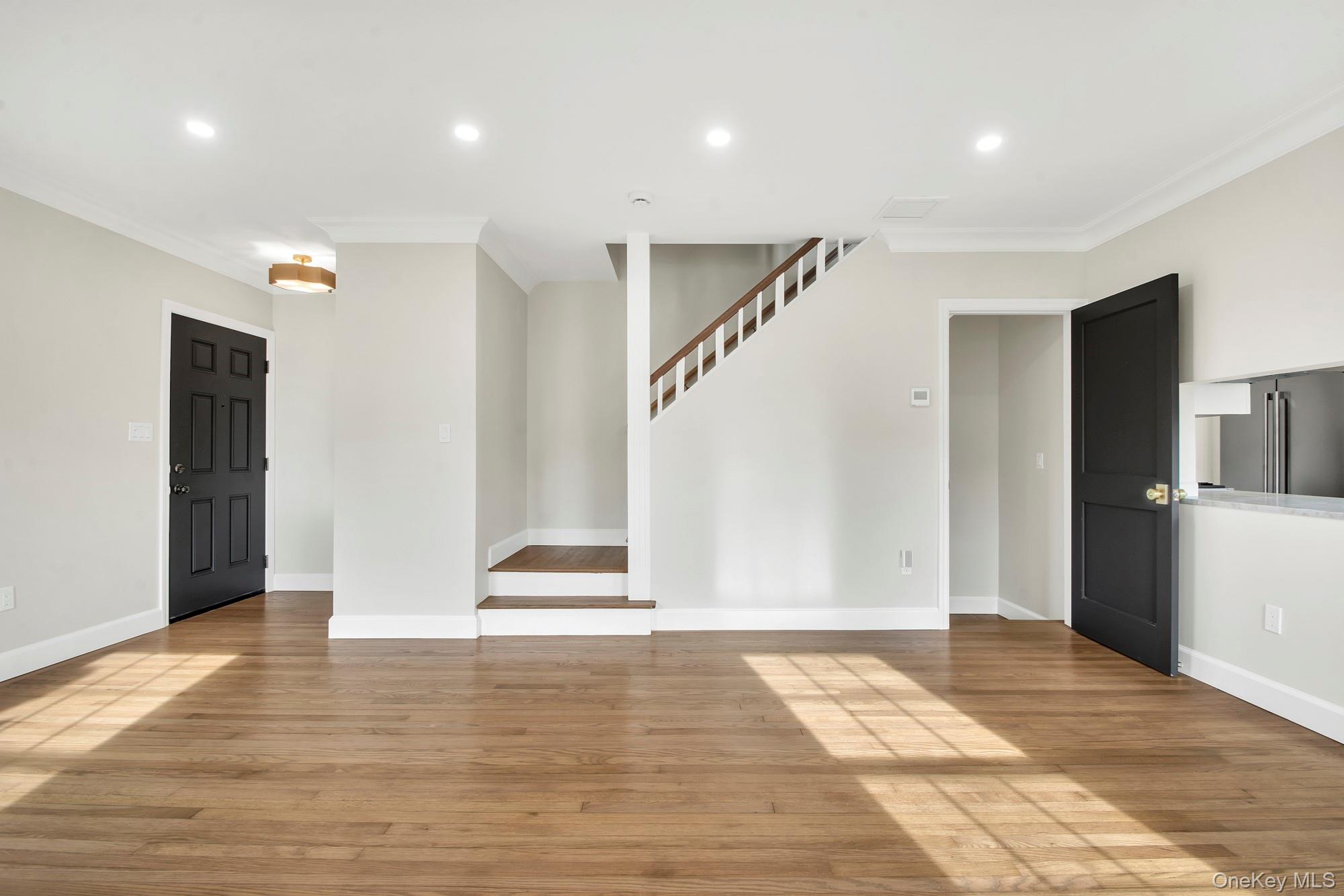 2 Bayview Court Manhasset, NY 11030 - Photo 7 of 21 Open living room with recessed lighting, light wood-style flooring, ornamental molding, and stairway