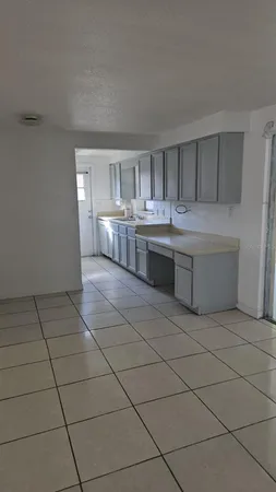 a room with kitchen island stainless steel appliances a sink and cabinets