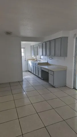a room with kitchen island stainless steel appliances a sink and cabinets