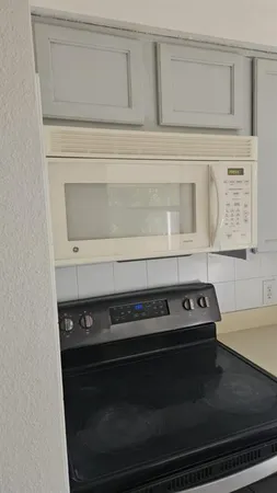 a stove top oven sitting inside of a kitchen