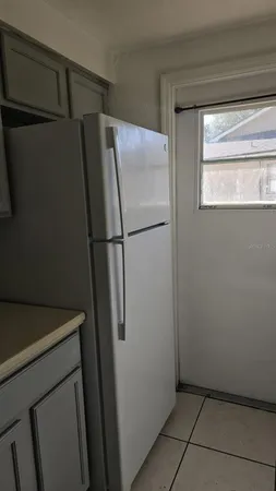 a white refrigerator freezer and a microwave in a shelf