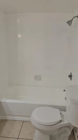 a white toilet sitting next to a bath tub