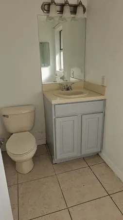 a bathroom with a granite countertop toilet sink and mirror