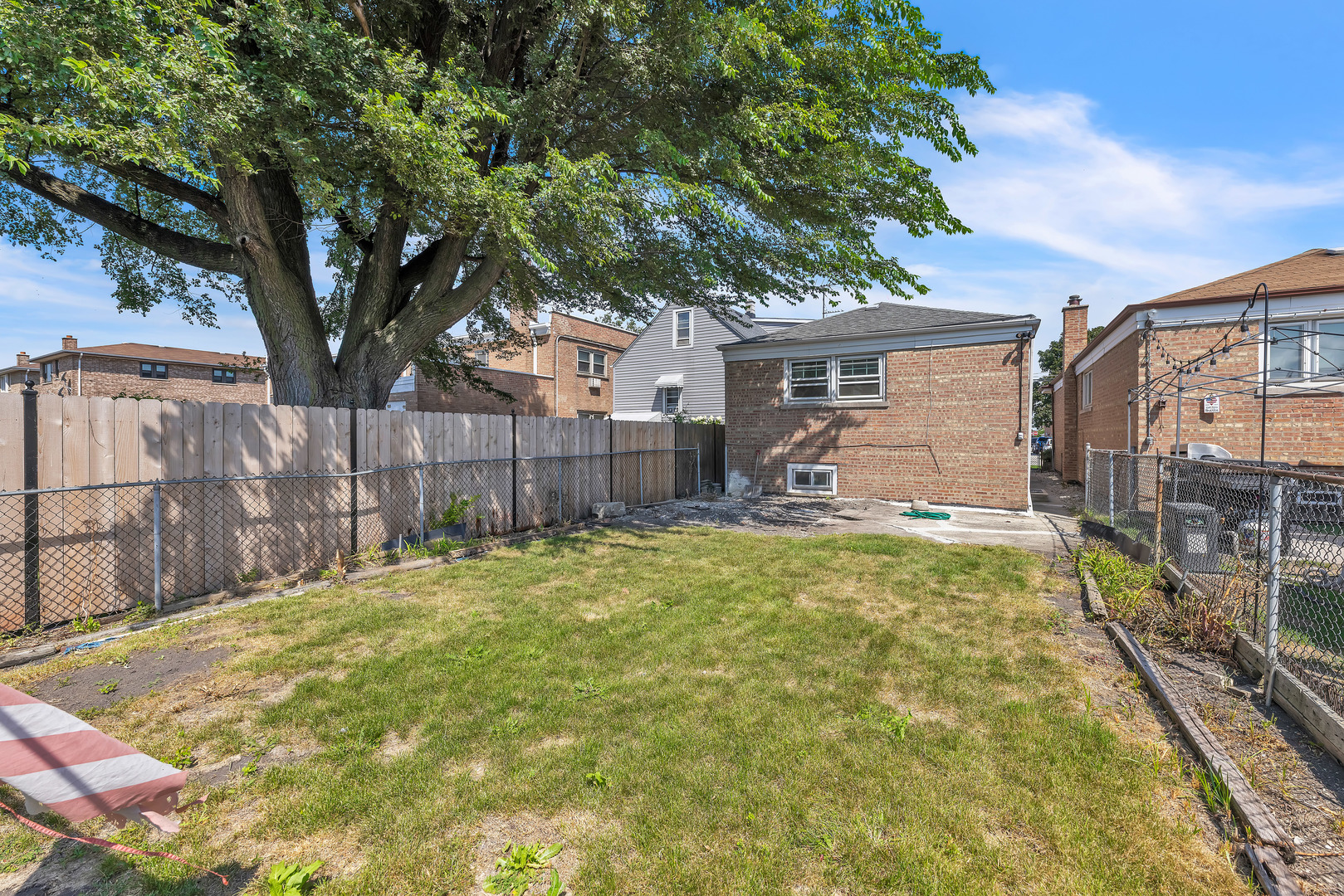 5331 West 53rd Place Chicago, IL 60638 - Photo 23 of 28 a backyard of a house with table and chairs under an umbrella