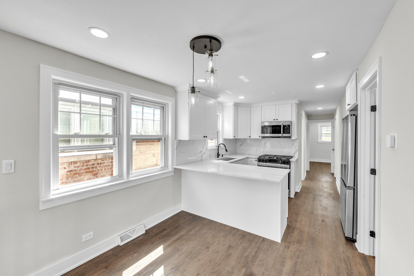 5331 West 53rd Place Chicago, IL 60638 - Photo 6 of 28 a kitchen with kitchen island white cabinets and wooden floor