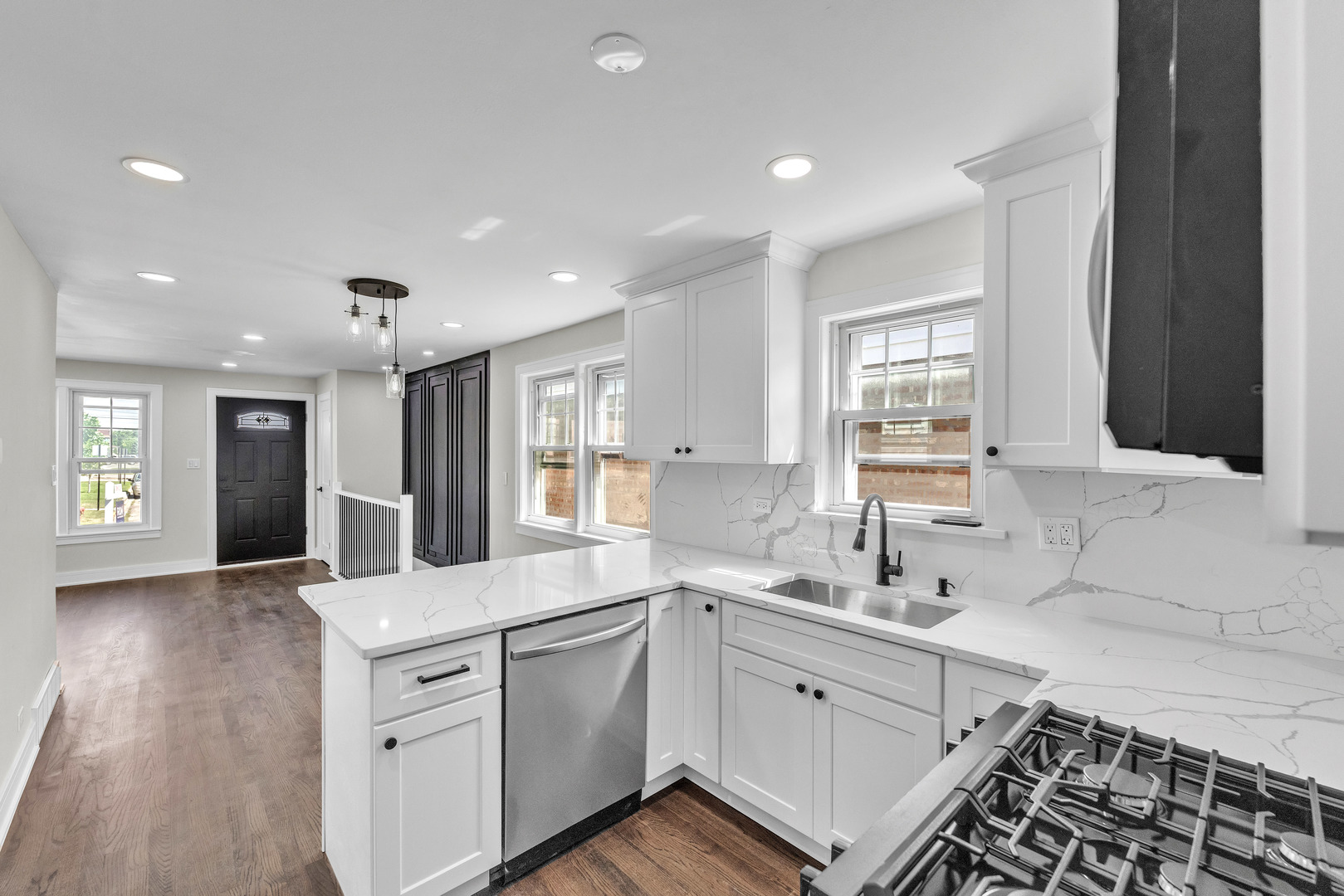 5331 West 53rd Place Chicago, IL 60638 - Photo 7 of 28 a large white kitchen with granite countertop a large window and white stainless steel appliances