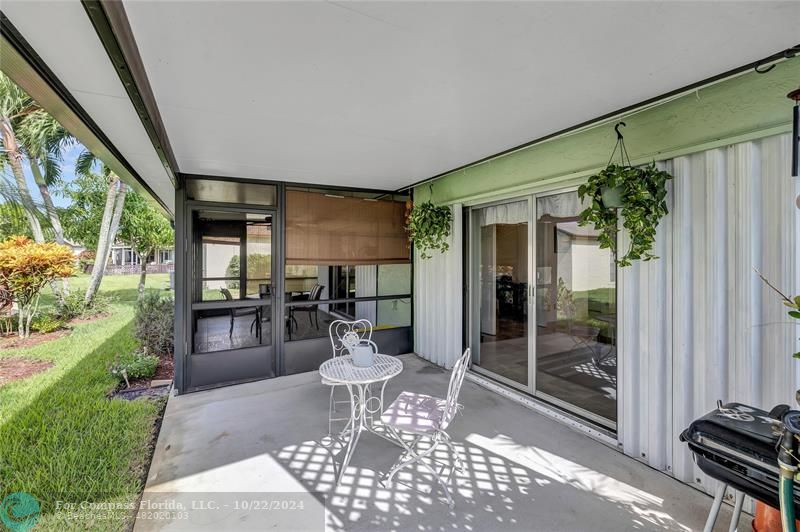 7359 Pine Park Drive North Lake Worth, FL 33467 - Photo 31 of 47 a view of a patio with table and chairs and potted plants