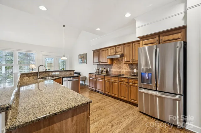a kitchen with stainless steel appliances granite countertop a sink refrigerator and stove
