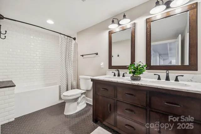 a bathroom with a double vanity sink toilet and shower