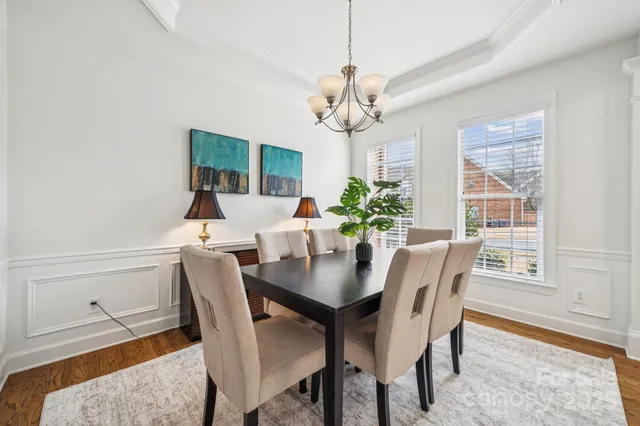 a view of a dining room with furniture a chandelier and wooden floor