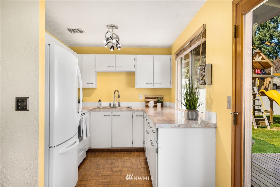 4612 Northeast 23rd Street Renton, WA 98059 - Photo 12 of 24 a kitchen with a refrigerator a stove a sink and a window