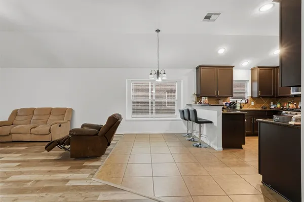 a living room with furniture a flat screen tv and kitchen view