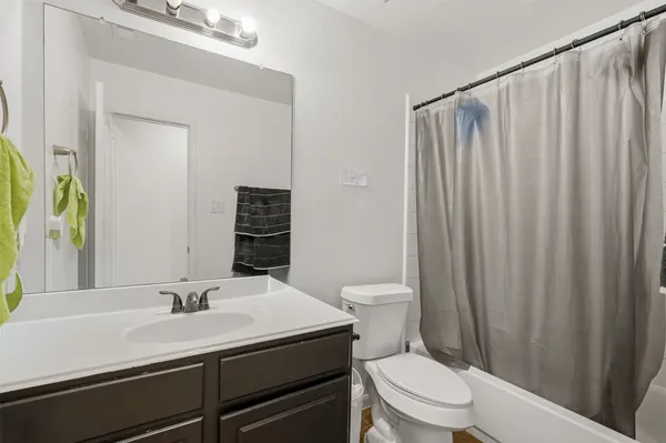 a bathroom with a sink a toilet a mirror and shower curtain