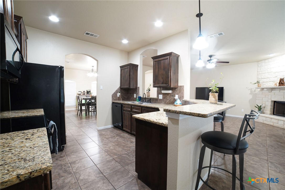 3422 Doss Street Copperas Cove, TX 76522 - Photo 12 of 29 a kitchen with stainless steel appliances kitchen island granite countertop a table chairs and a refrigerator