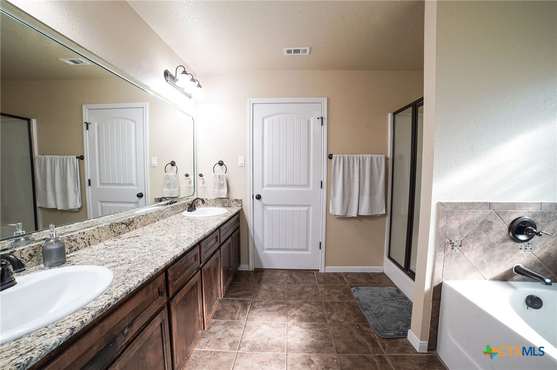 3422 Doss Street Copperas Cove, TX 76522 - Photo 18 of 29 a bathroom with a granite countertop sink and a mirror