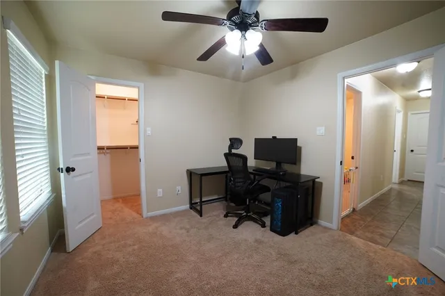 en view of a workspace with furniture and a window