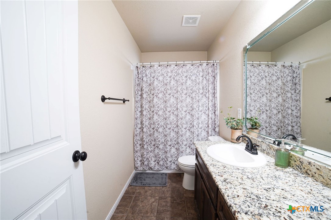 3422 Doss Street Copperas Cove, TX 76522 - Photo 24 of 29 a bathroom with a granite countertop sink a mirror and shower