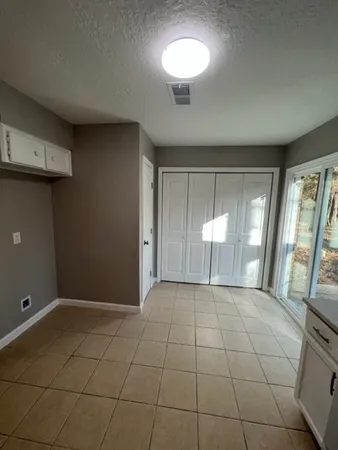 a view of an empty room with glass door and a window