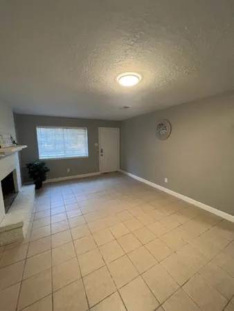 an empty room with a fireplace and windows