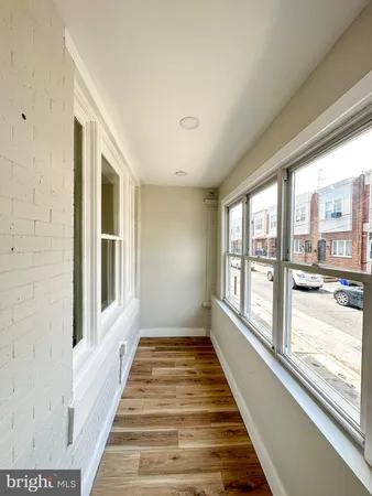 a view of a room with wooden floor and windows
