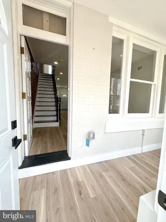 a view of a living room with wooden floor and stairs