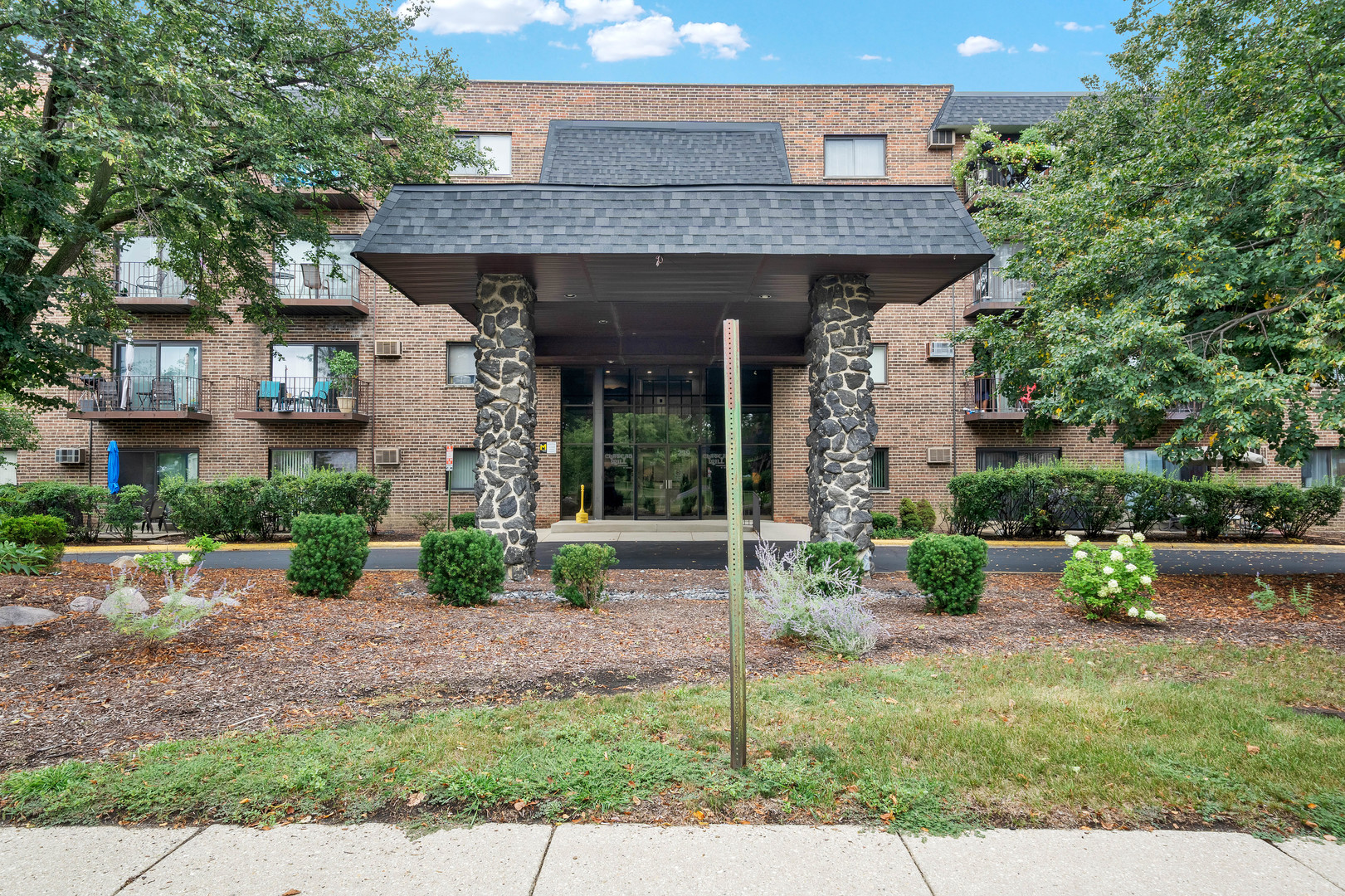 a front view of a house with a garden and plants