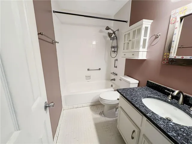 a bathroom with a granite countertop sink toilet and shower