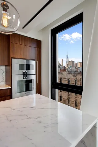 a large kitchen with granite countertop a sink dishwasher a stove and a refrigerator with wooden floor