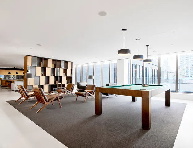 a living room with furniture a ceiling fan and kitchen view